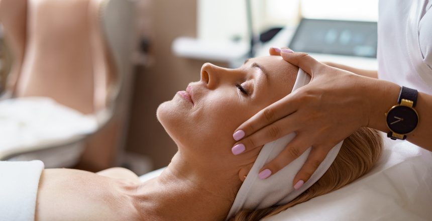 Face massage. Close-up of adult woman getting spa massage treatment at beauty spa salon. Spa skin and body care. Facial beauty treatment. Cosmetology.