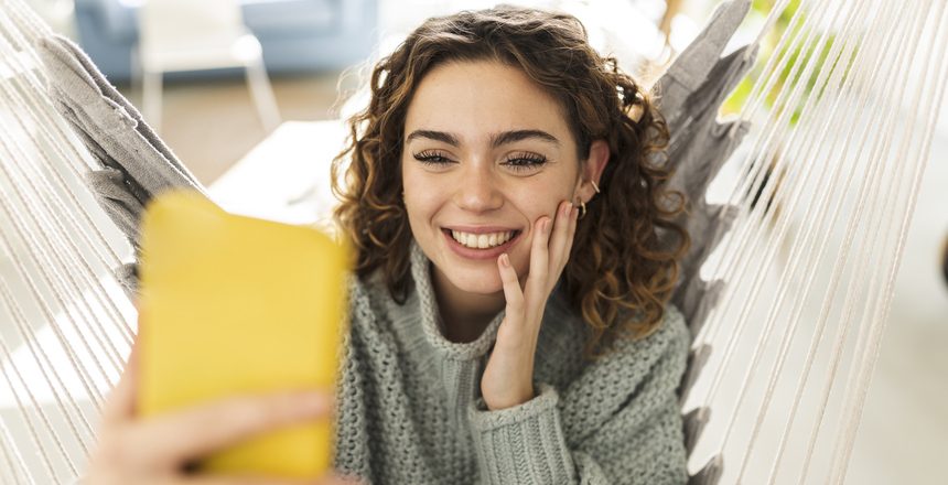 Pretty woman making video call with smartphone, at home